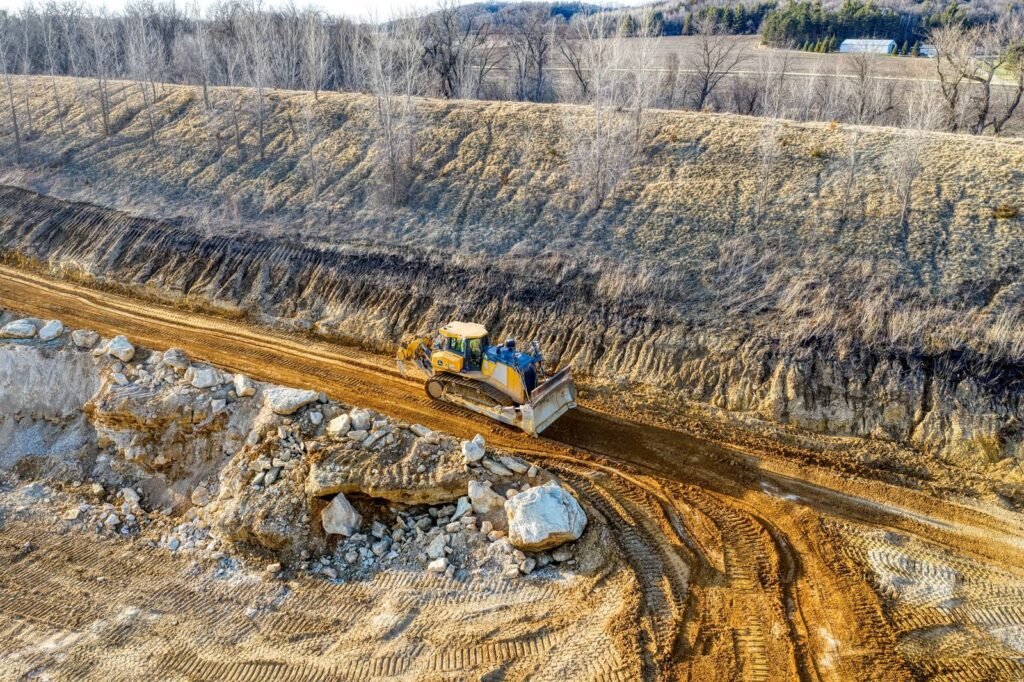 A bulldozer operating on a dirt road in a rural setting