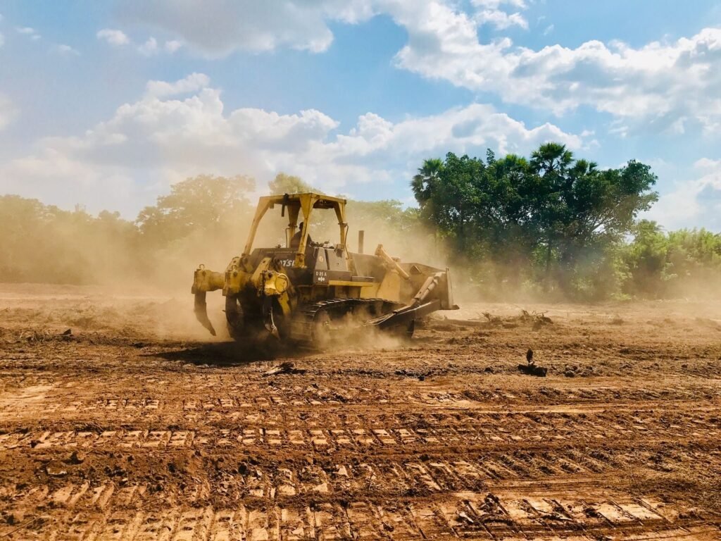 A bulldozer working on a cleared dirt field